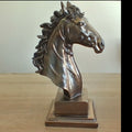 A metallic bronze horse head bust sculpture on a rectangular base.