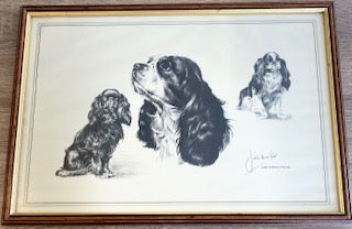 A framed vintage black and white dog sketch print of three King Charles Spaniels by artist Joel Kirk, in a dark wood frame with gold inner border.